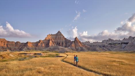 Hikers immersed in the otherworldly wilderness of Badlands National Park Hikers immersed in the otherworldly wilderness of Badlands National Park