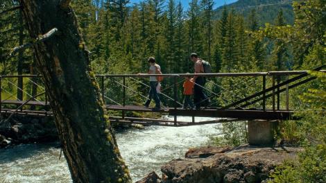 A family hiking over a bridge A family hiking over a bridge