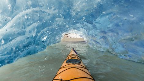 Kayaking in a glacier cave at Mendenhall Glacier Lake in Juneau, Alaska Kayaking in a glacier cave at Mendenhall Glacier Lake in Juneau, Alaska