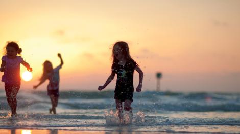 Children playing in the surf at sunset near St. Petersburg, Florida Children playing in the surf at sunset near St. Petersburg, Florida
