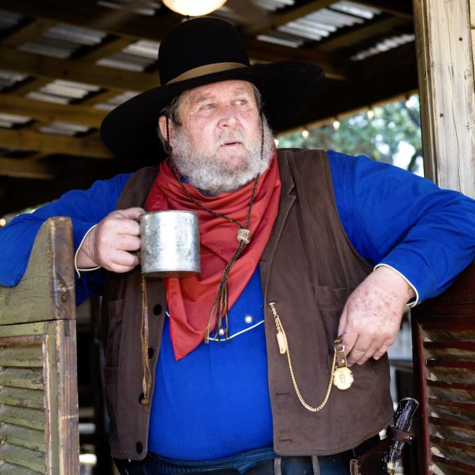 Cowboy with a drink standing outside a saloon in Texas Cowboy with a drink standing outside a saloon in Texas