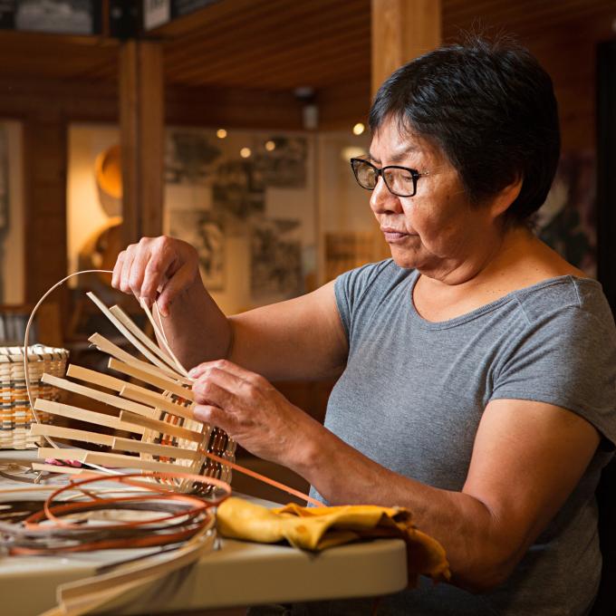 Cherokee artisan weaving a basket at the Qualla Arts & Crafts Mutual in Cherokee, North Carolina Cherokee artisan weaving a basket at the Qualla Arts & Crafts Mutual in Cherokee, North Carolina