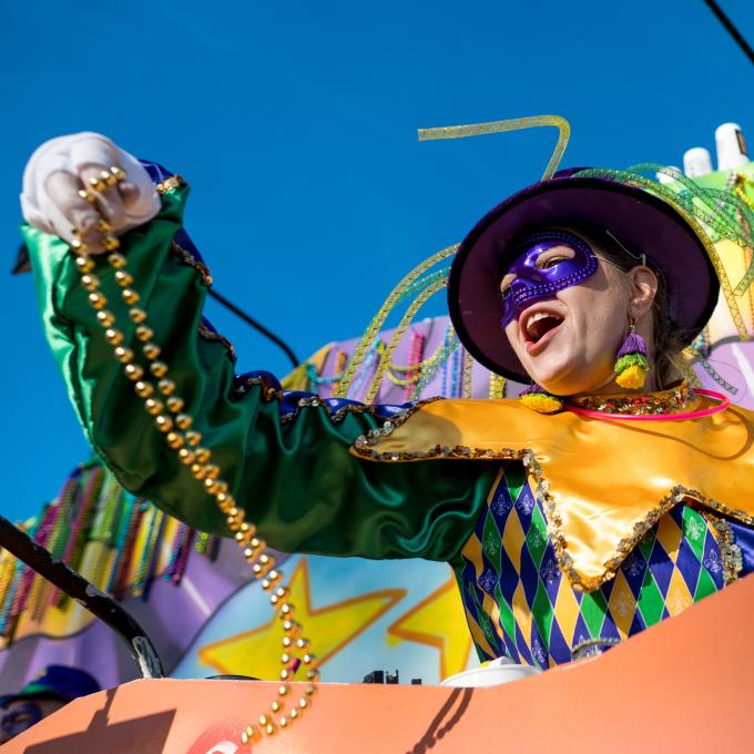 Tossing beads from the Krewe of Gemini float during a Mardi Gras parade in New Orleans, Louisiana Tossing beads from the Krewe of Gemini float during a Mardi Gras parade in New Orleans, Louisiana