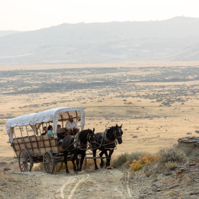 A covered wagon travels the historic roads just outside Casper, Wyoming A covered wagon travels the historic roads just outside Casper, Wyoming