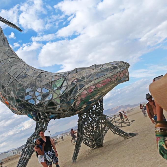Participants pose for a photo with a sculpture during Burning Man in Black Rock City, Nevada Participants pose for a photo with a sculpture during Burning Man in Black Rock City, Nevada