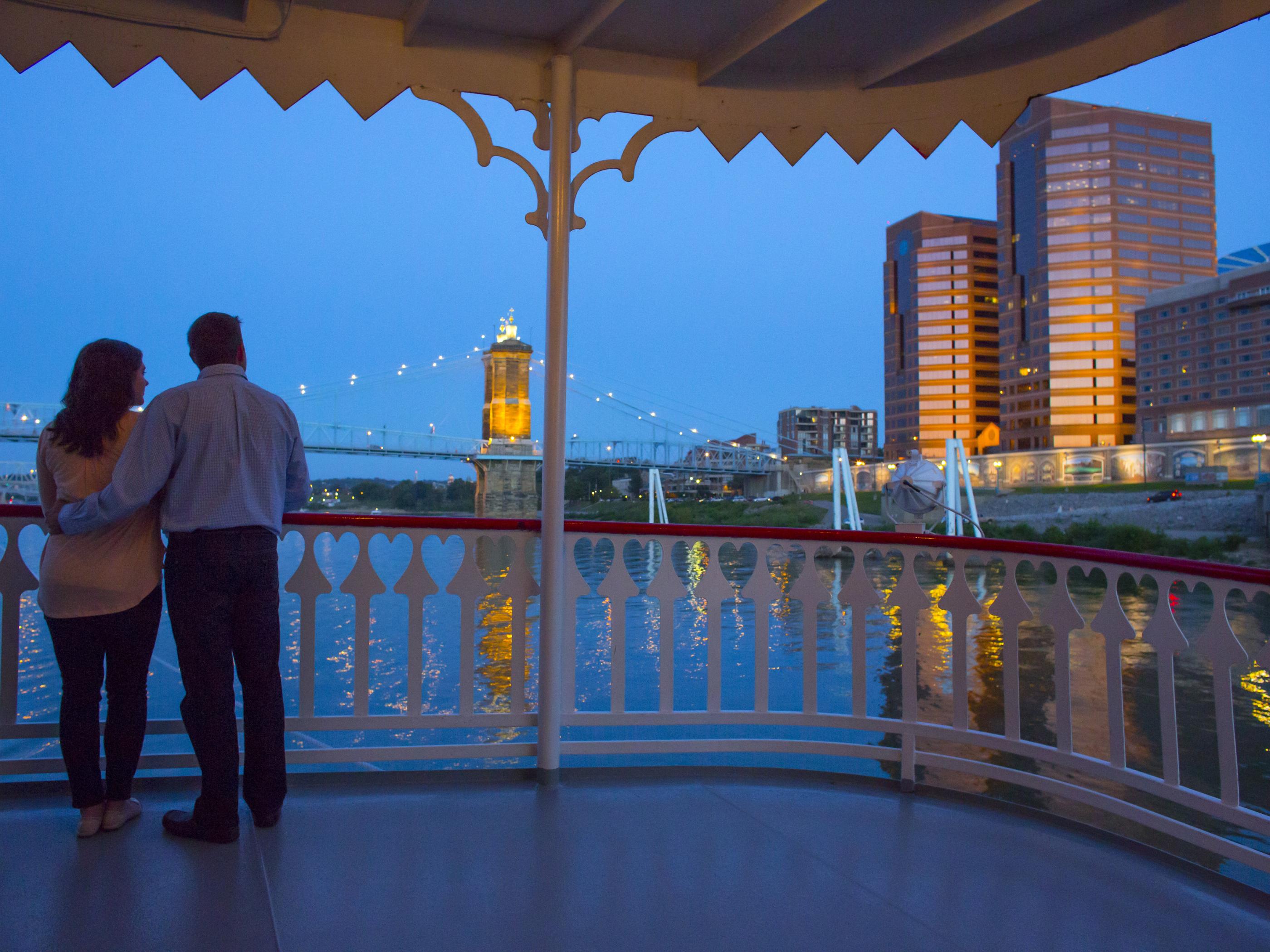 A couple take in the Roebling Bridge from the deck of a BB Riverboat A couple take in the Roebling Bridge from the deck of a BB Riverboat