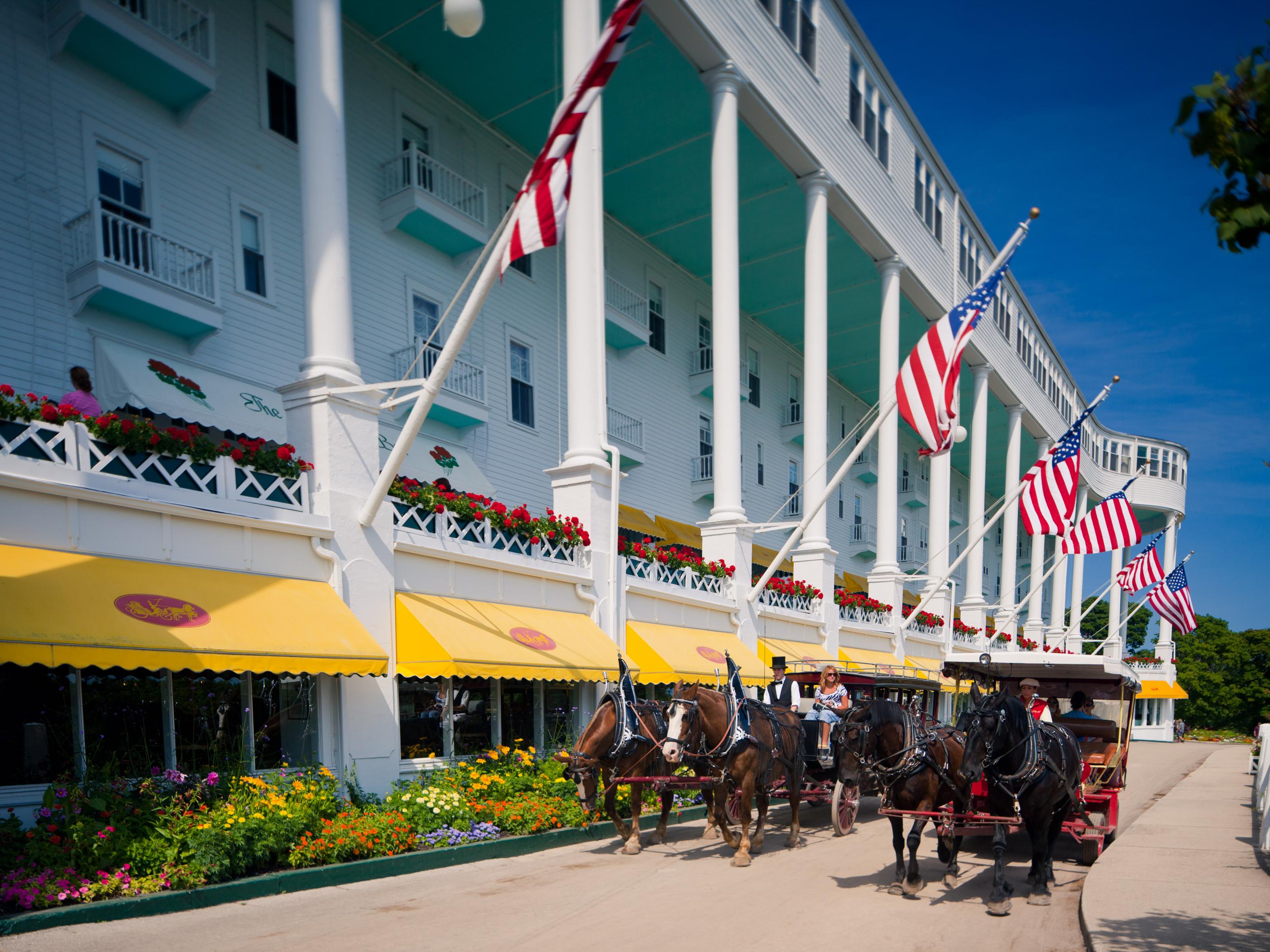 Horse-drawn carriages passing outside The Grand Hotel on Mackinac Island Horse-drawn carriages passing outside The Grand Hotel on Mackinac Island