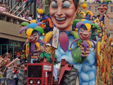 A colorful Mardi Gras float parades through the street A colorful Mardi Gras float parades through the street